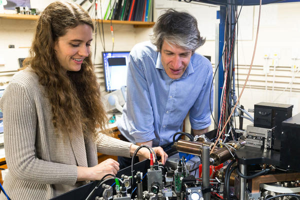Two scientists talking over a complex experiment